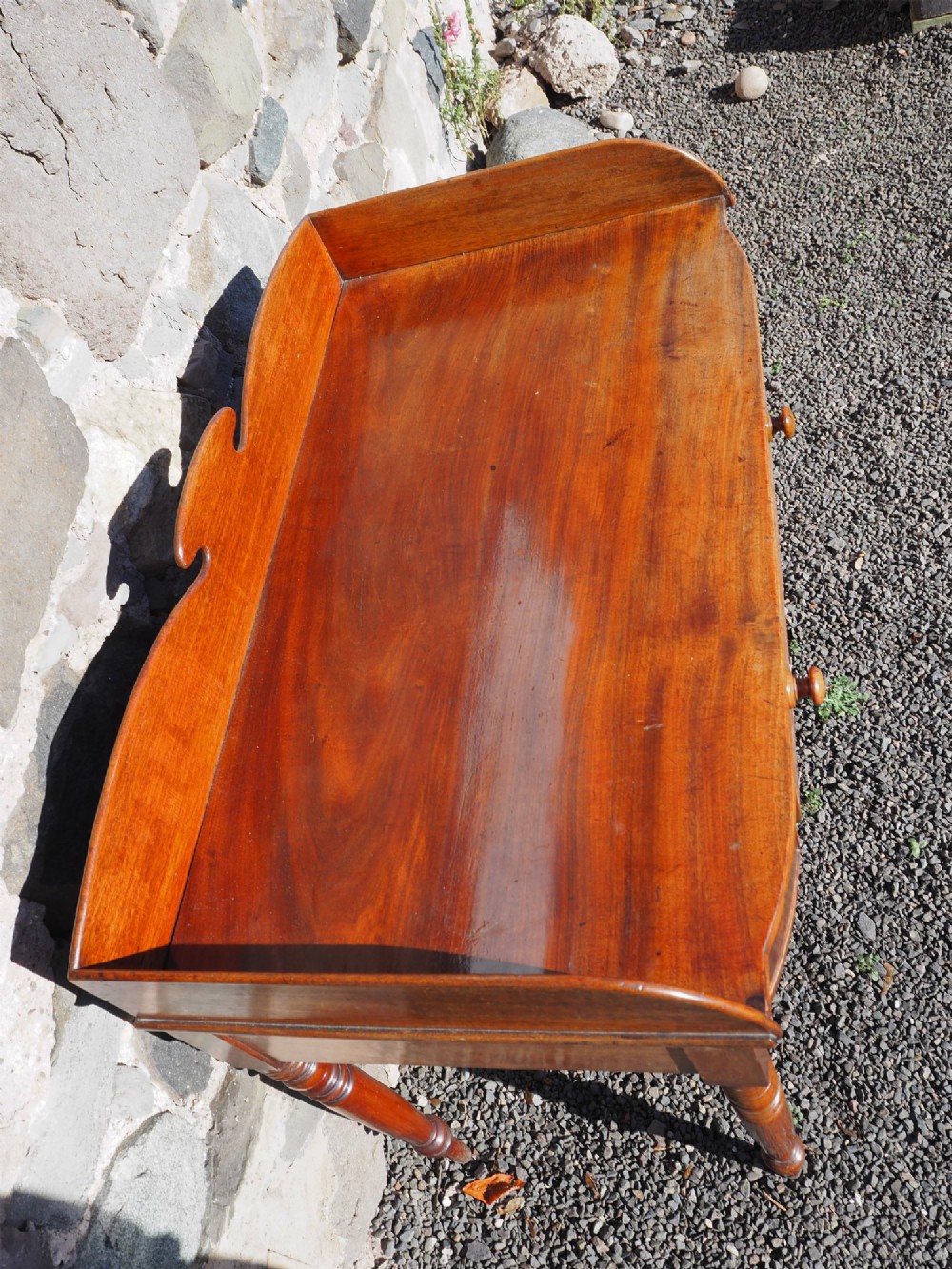 A Georgian mahogany dressing table featuring a raised gallery back, a single drawer with turned wooden knobs, and slender turned legs. View IV