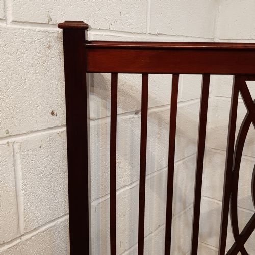 fig 1. A pair of Edwardian mahogany single bed frames featuring slatted headboards and footboards accented with central geometric oval motifs and standing on castors.