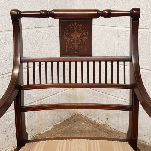 fig 2. A pair of Edwardian mahogany armchairs featuring inlaid marquetry backsplats, vertical spindles, sweeping armrests, and striped fabric upholstery.