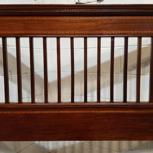 fig 2. An Edwardian mahogany king size bedstead featuring vertical slatted panels on both headboard and footboard, decorated with fine wood inlay.