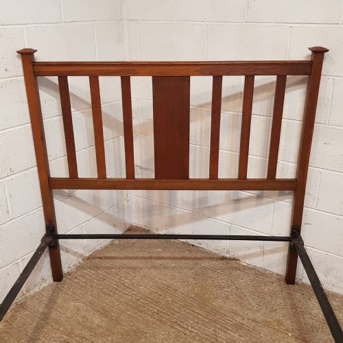 fig 2. An Edwardian oak bedstead featuring slatted timber headboard and footboard panels with a central carved motif.