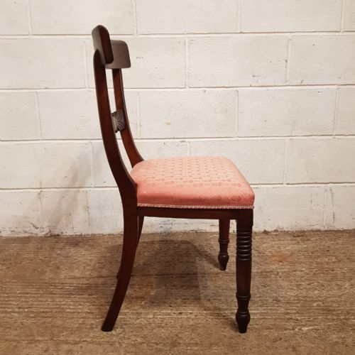 fig 1. A set of six Regency mahogany dining chairs featuring tablet top rails, carved central splats, dusty pink patterned upholstery, and turned reeded front legs.
