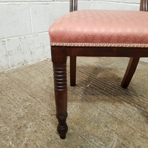 fig 2. A set of six Regency mahogany dining chairs featuring tablet top rails, carved central splats, dusty pink patterned upholstery, and turned reeded front legs.