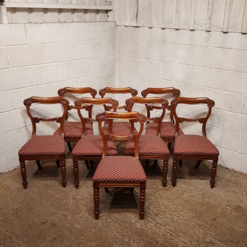 fig 1. A set of carved walnut Victorian dining chairs featuring red patterned upholstered seats and turned front legs.
