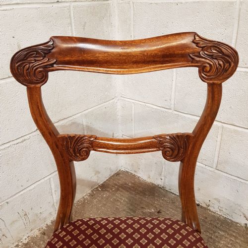 fig 2. A set of carved walnut Victorian dining chairs featuring red patterned upholstered seats and turned front legs.