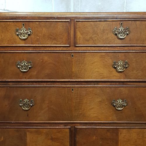 fig 1. A 1920s burr walnut tallboy featuring three upper drawers with brass handles above a double-door cupboard on turned feet.
