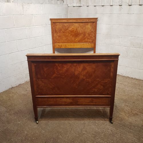 fig 2. A pair of late Victorian golden satinwood single bed frames featuring geometric veneer panels and molded crest rails on brass castors.