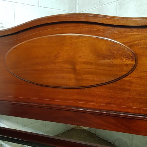 fig 1. An Edwardian mahogany double bedstead featuring curved top rails and recessed oval panels on both the headboard and footboard.