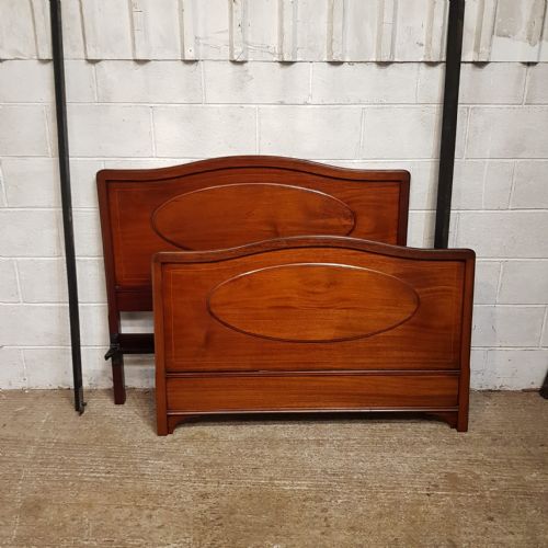 fig 2. An Edwardian mahogany double bedstead featuring curved top rails and recessed oval panels on both the headboard and footboard.