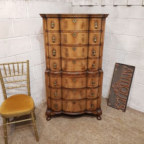 fig 1. A tall Queen Anne style burr walnut chest on chest with a serpentine front, brass drop handles, and cabriole legs.