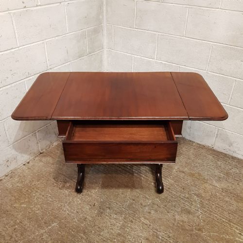 fig 2. A William IV mahogany sofa table featuring hinged drop-leaf side flaps, twin end supports, and a central turned stretcher.