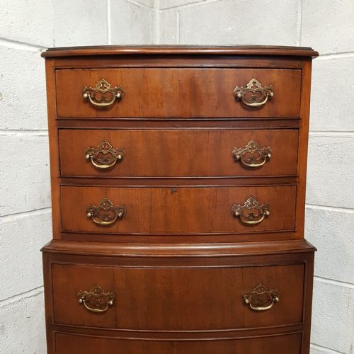 fig 1. A bow-fronted mahogany dwarf chest on chest featuring seven drawers with brass handles and bracket feet.