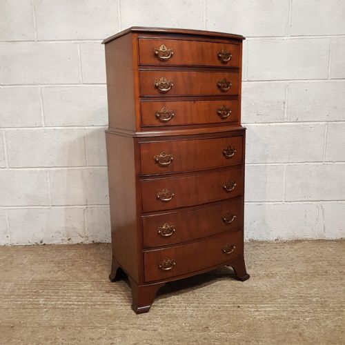 fig 2. A bow-fronted mahogany dwarf chest on chest featuring seven drawers with brass handles and bracket feet.