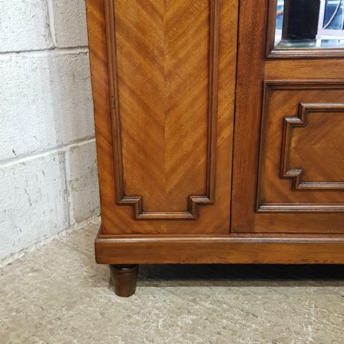fig 2. A late Victorian mahogany single door wardrobe featuring a central mirrored panel flanked by chevron-veneered wood sections and topped with a moulded cornice.