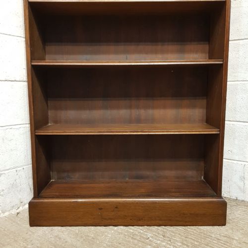 fig 1. A tall Edwardian dark oak open bookcase featuring eight fixed shelves, a top moulded cornice, and a sturdy plinth base.