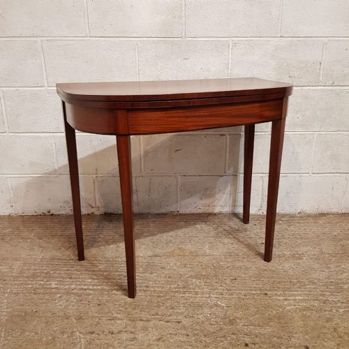 fig 1. A Regency mahogany D-shaped fold-over games table supported by tapered legs.