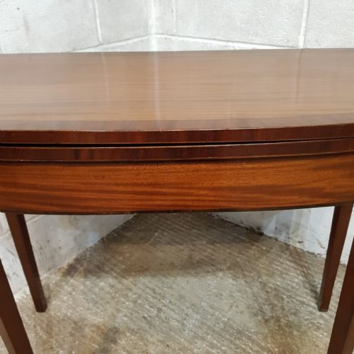 fig 2. A Regency mahogany D-shaped fold-over games table supported by tapered legs.