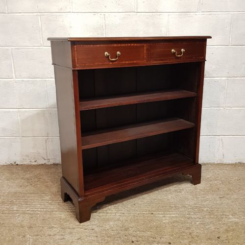 fig 1. An Edwardian dark mahogany open bookcase featuring two top drawers with brass drop handles above open wooden shelves.