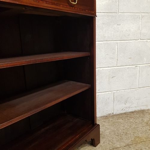 fig 2. An Edwardian dark mahogany open bookcase featuring two top drawers with brass drop handles above open wooden shelves.
