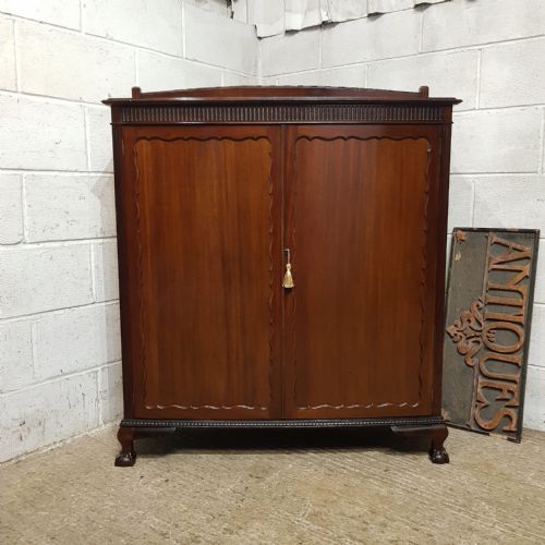 AN EDWARDIAN BOW FRONTED CUPBOARD IN MAHOGANY C1900