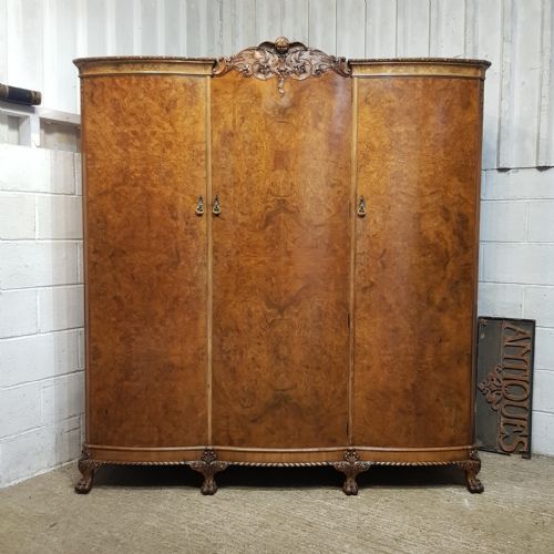 A BURR WALNUT SERPENTINE FRONTED TRIPLE WARDROBE C1920