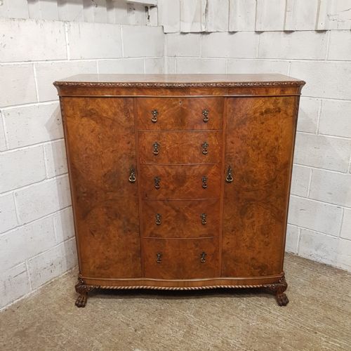 A BURR WALNUT SERPENTINE FRONTED TALL BOY C1920