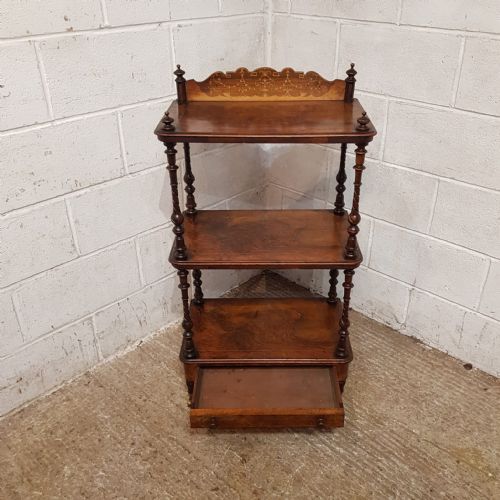 fig 1. A three-tier Victorian burr walnut whatnot featuring spiral turned columns, an inlaid top gallery, a lower drawer, and brass castors.