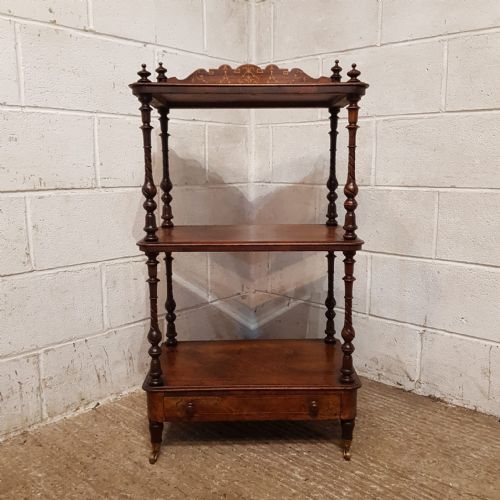 fig 2. A three-tier Victorian burr walnut whatnot featuring spiral turned columns, an inlaid top gallery, a lower drawer, and brass castors.