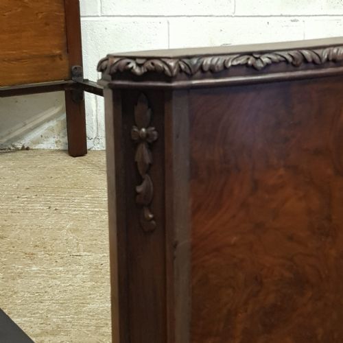 fig 2. A pair of 1920s burr walnut single beds featuring shaped arched headboards, panelled footboards, and carved feet.