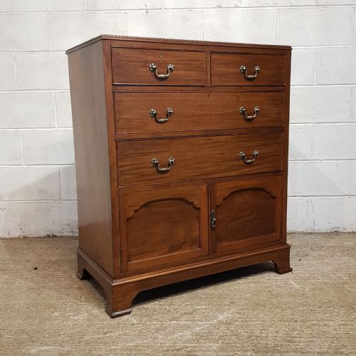 fig 2. An Edwardian mahogany tallboy chest featuring two short drawers over two long drawers and a double-door cupboard base on bracket feet.