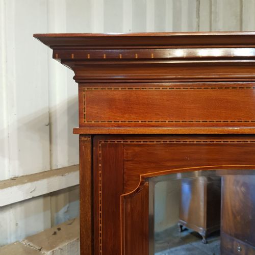 fig 2. An Edwardian mahogany triple wardrobe featuring a central cupboard with urn marquetry above four drawers, flanked by two arched mirrored doors.