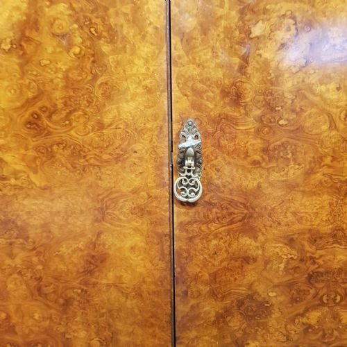 fig 2. A small 1920s burr walnut fitted wardrobe featuring double doors with book-matched grain, a carved top crest, and short cabriole legs.
