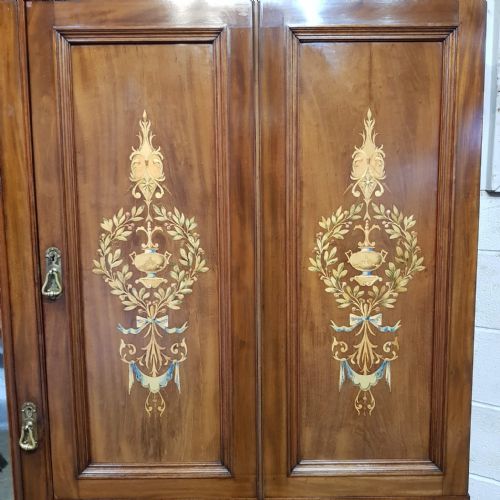 fig 1. A late Victorian mahogany combination wardrobe featuring a full-length mirrored door, marquetry-inlaid cupboards, and four drawers with round brass handles.