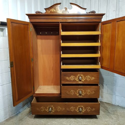 fig 2. A late Victorian mahogany combination wardrobe featuring a full-length mirrored door, marquetry-inlaid cupboards, and four drawers with round brass handles.