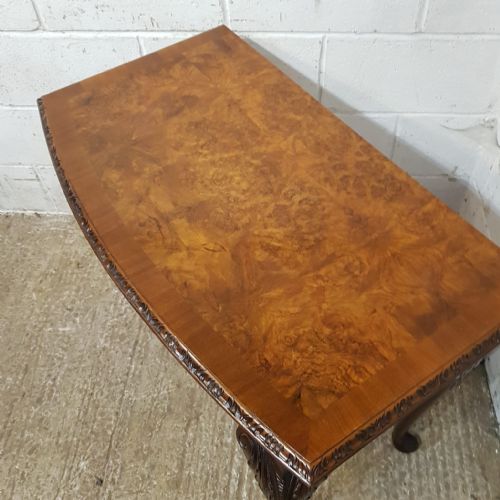 fig 1. A 1920s burr walnut bow-fronted console table featuring carved cabriole legs with shell detail on the knees.