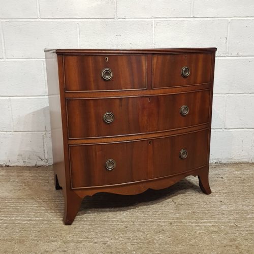 fig 1. A small mahogany bow-fronted chest of drawers featuring two short drawers over two long drawers with brass ring handles.