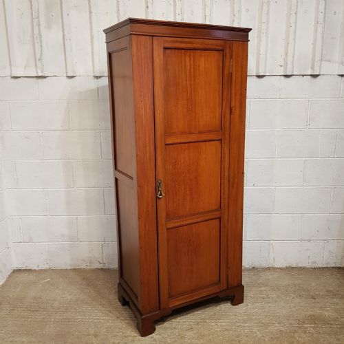 fig 2. A tall, narrow mahogany sentry box wardrobe featuring a single three-panel door, brass handle, moulded top cornice, and bracket feet.