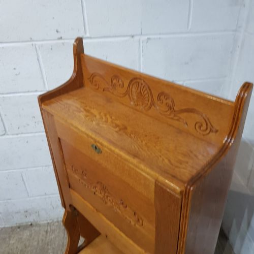 fig 1. An Arts and Crafts golden oak drop-front Larkin bureau featuring carved shell motifs on the flap and top rail, supported by tall shaped sides and lower shelving.