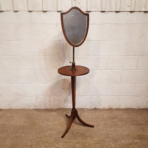fig 2. A late Victorian mahogany shaving stand featuring a shield-shaped adjustable mirror, a round central shelf, and a turned pedestal on a tripod base.