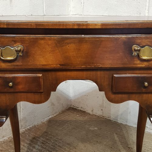 fig 1. A burr walnut lowboy table featuring cabriole legs, pad feet, a shaped lower apron, and three drawers with brass handles.