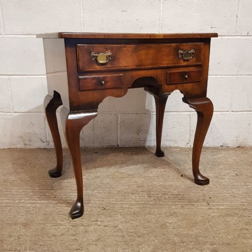 fig 2. A burr walnut lowboy table featuring cabriole legs, pad feet, a shaped lower apron, and three drawers with brass handles.