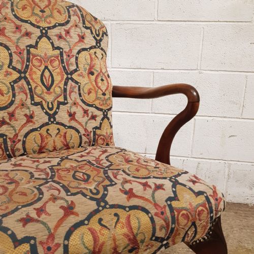 fig 1. A pair of 1920s walnut armchairs featuring patterned tapestry upholstery, cabriole front legs, and brass stud trim.