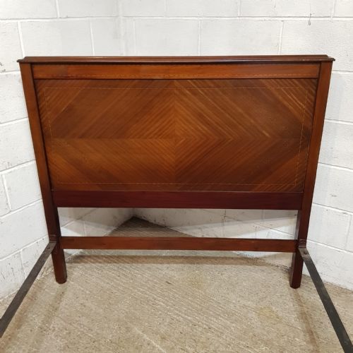 fig 2. An Edwardian mahogany double bedstead featuring geometric diamond parquetry veneered panels on the headboard and footboard.