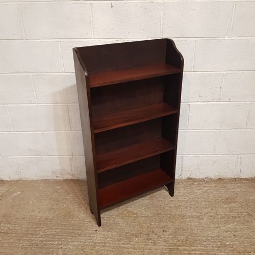 fig 1. A matching pair of dark mahogany open bookcases featuring four fixed shelves and shaped top sides.