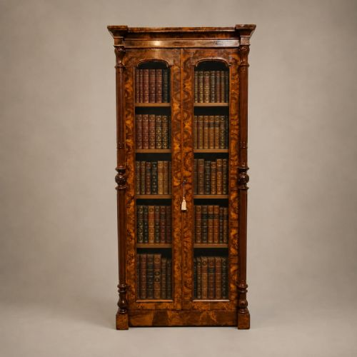 fig 1. A tall, narrow Victorian burr walnut glazed bookcase with twin glass doors and carved side columns.