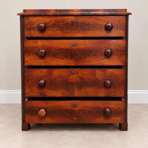 fig 2. A Victorian flame mahogany four-drawer chest featuring turned wooden handles, brass keyhole escutcheons, and rounded side columns.