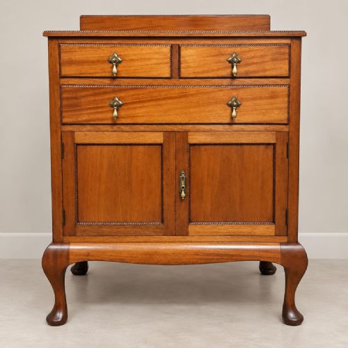 fig 1. An Edwardian mahogany tallboy featuring three top drawers over a two-door cupboard compartment, supported by cabriole legs with brass drop handles.