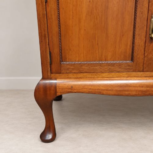 fig 2. An Edwardian mahogany tallboy featuring three top drawers over a two-door cupboard compartment, supported by cabriole legs with brass drop handles.