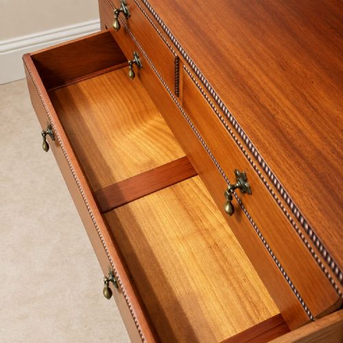 fig 1. An Edwardian mahogany chest of drawers featuring two short over two long drawers, brass drop handles, a low gallery back, and cabriole legs.