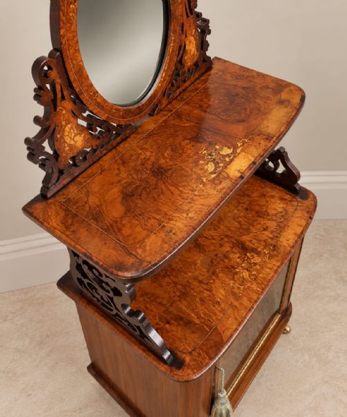 fig 1. A Victorian burr walnut side cabinet with a glazed single door, marquetry inlay details, an upper shelf tier, and an oval mirror crest.